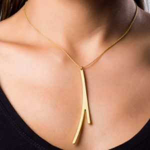 Ramification I neck pendant finished in matt gold on model.