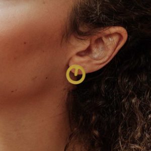 Clip earring in brass golden finish placed on ear