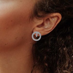 Clip earring in matt silver finish placed on ear