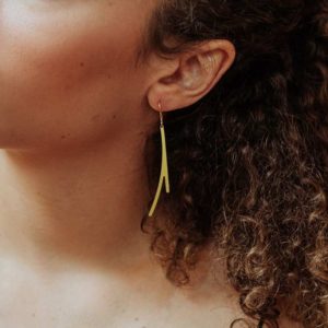 Ramification I earring in brass golden finish placed on ear