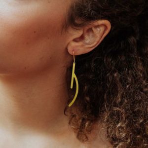 Ramification III earring in brass golden finish placed on ear